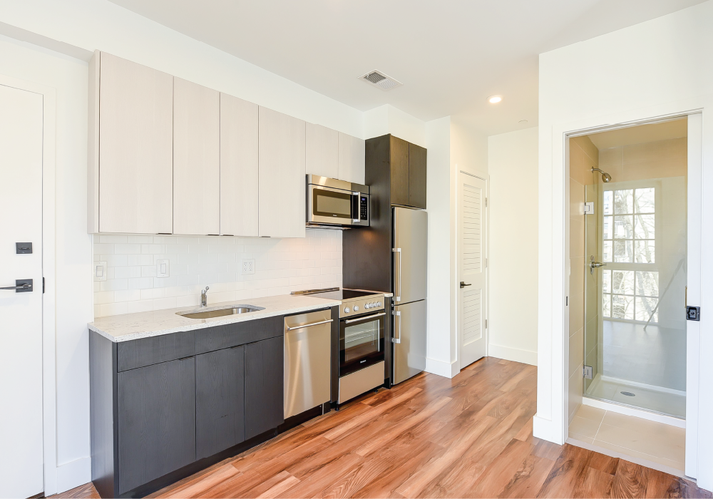 a kitchen with white cabinets and a stainless steel refrigerator