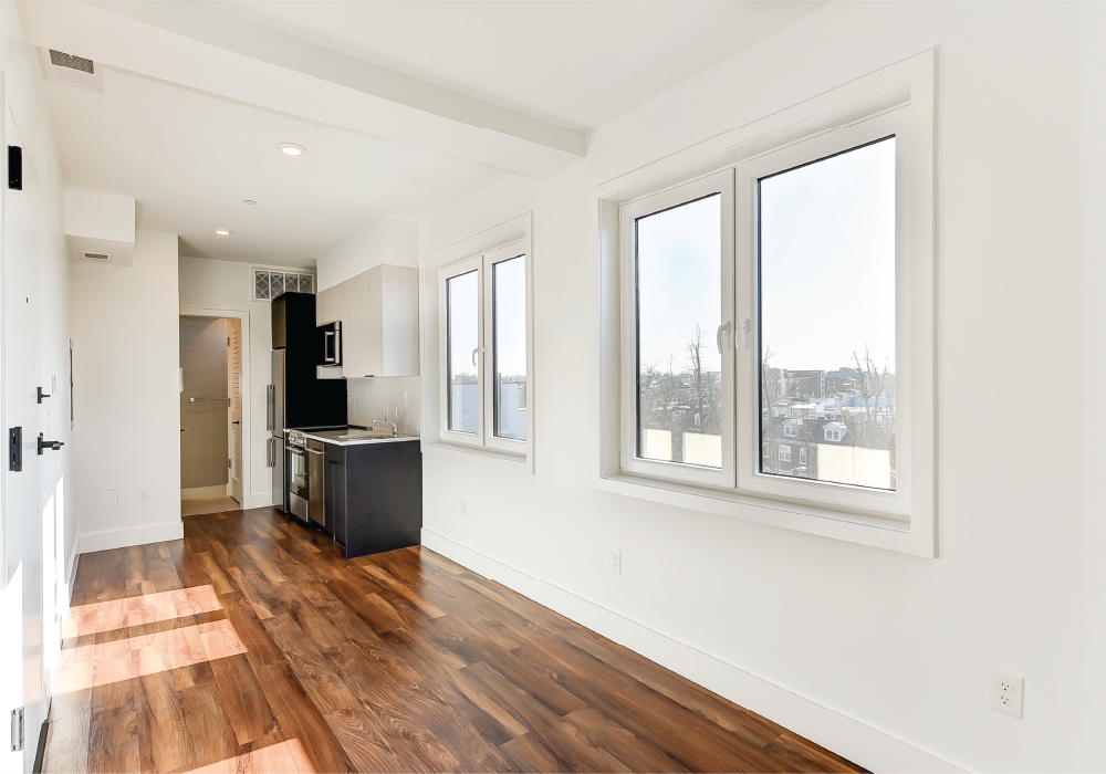 a living room with a hard wood floor and large windows