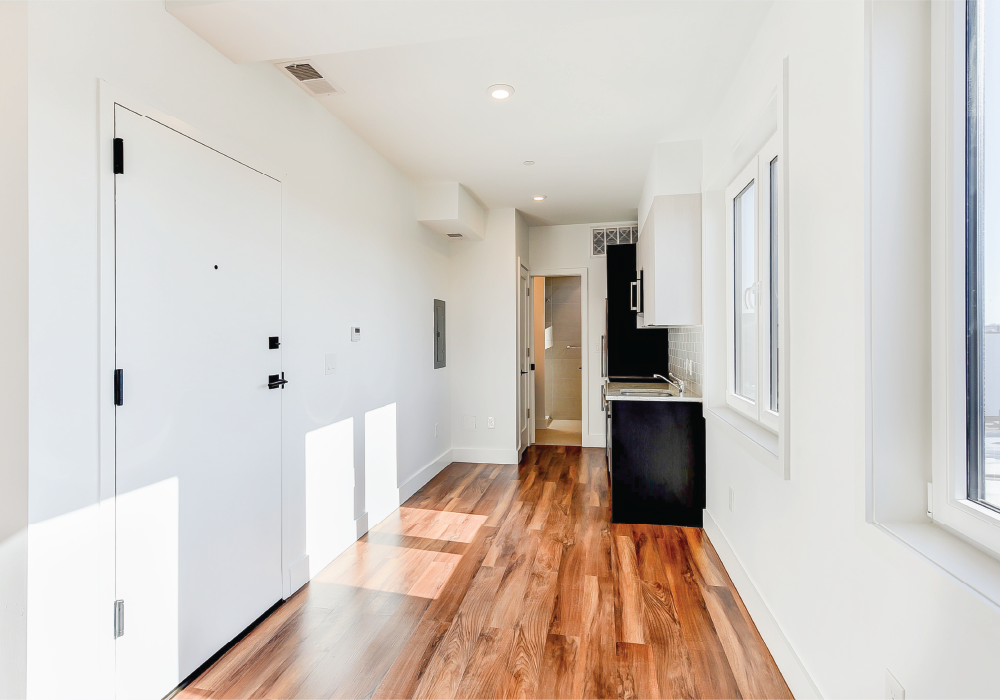 a renovated kitchen with white walls and wood floors