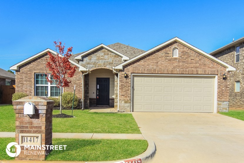 a tan brick house with a white garage door