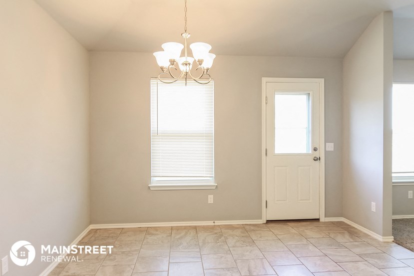 a dining room with a door and a chandelier