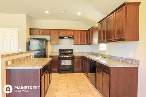 a kitchen with wooden cabinets and a stove and a sink