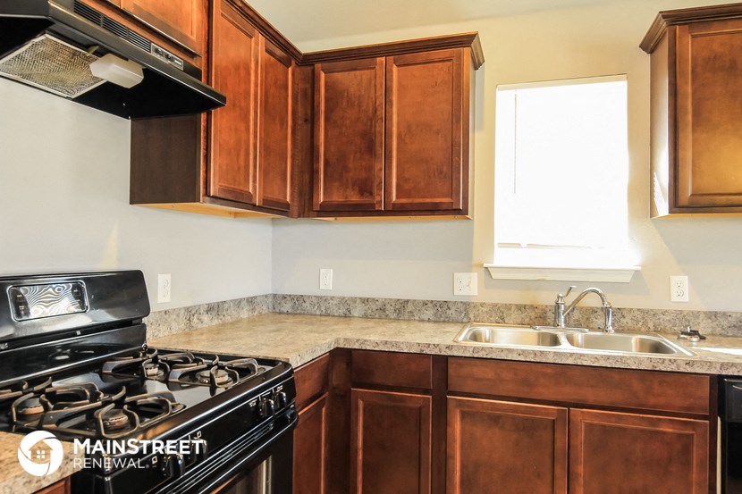 a kitchen with wooden cabinets and a stove and a sink