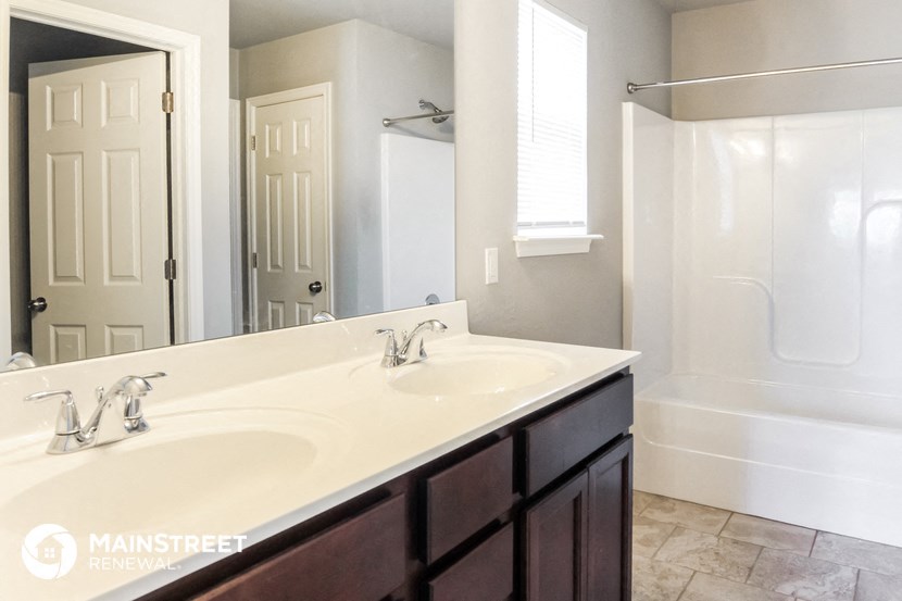 a bathroom with a sink and a shower and a mirror