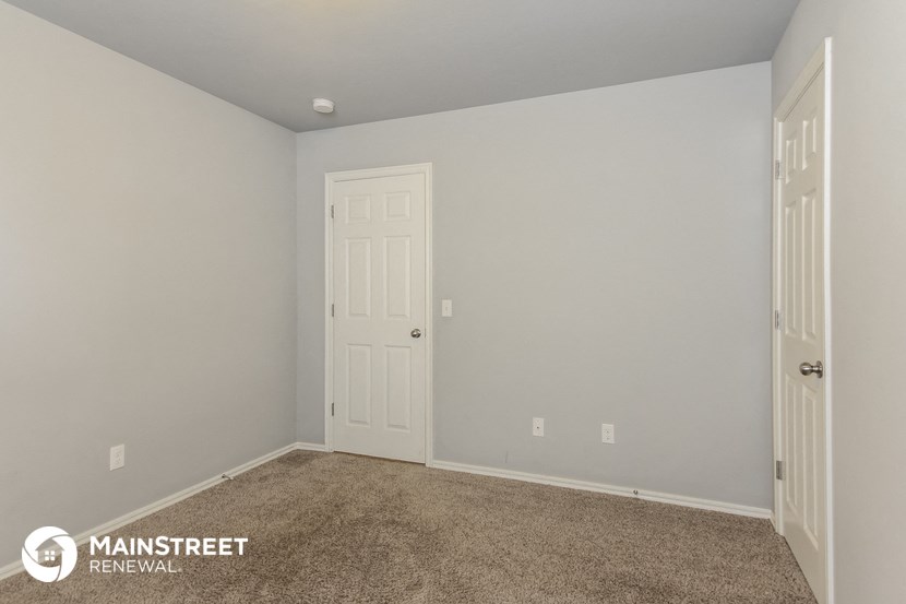 the upstairs bedroom has a carpeted floor and a white door