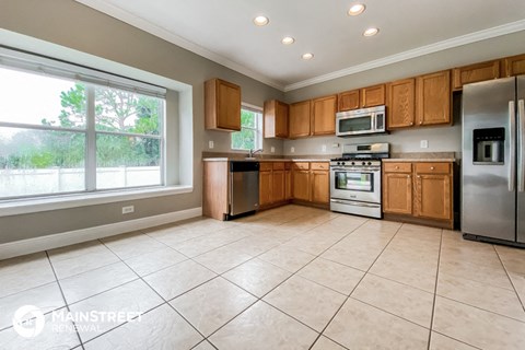 a large kitchen with wooden cabinets and stainless steel appliances
