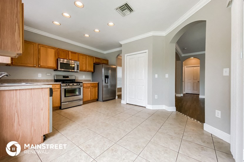 a large kitchen with wooden cabinets and stainless steel appliances