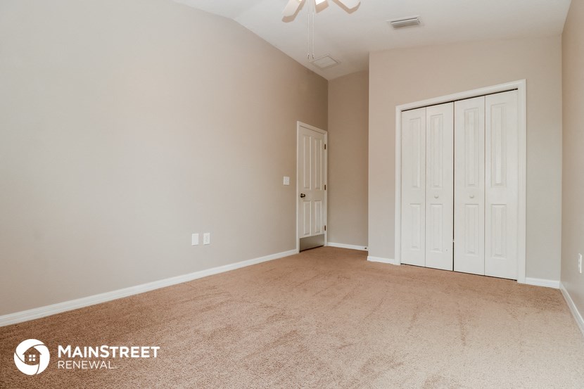 the spacious living room with two doors to the closet