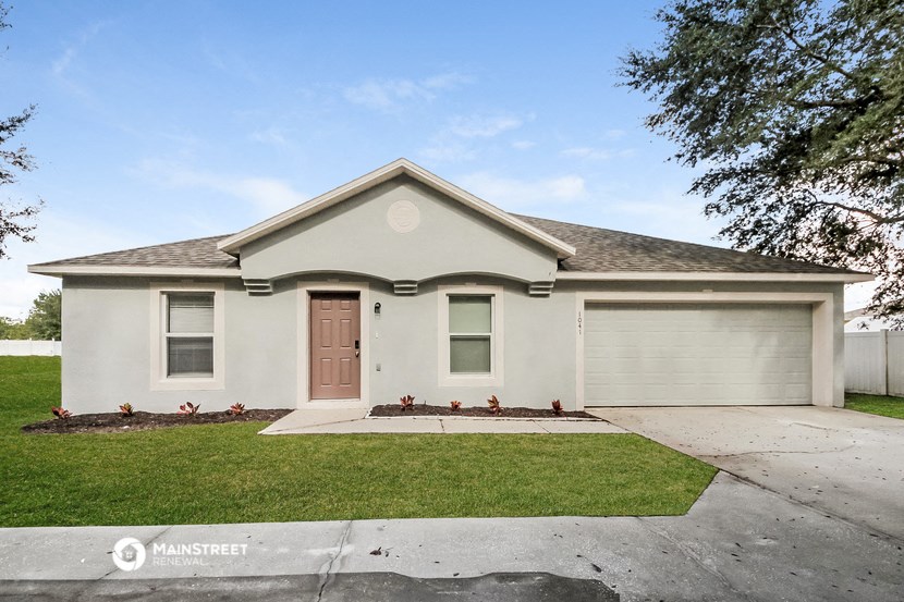 a white house with a sidewalk in front of it