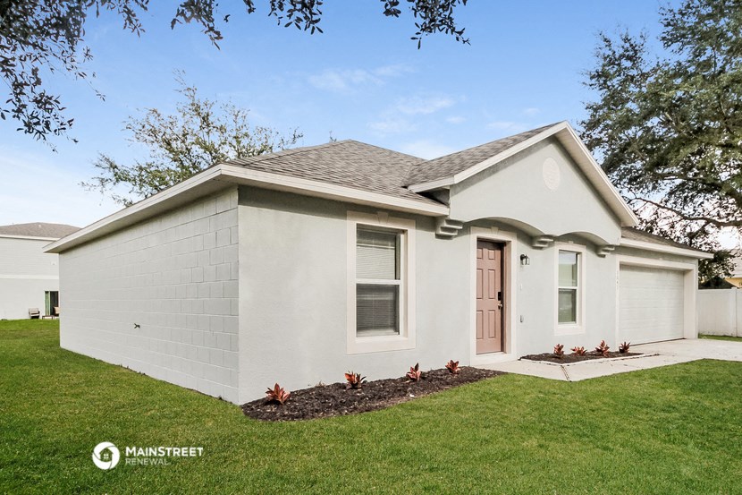 a small white house with a front yard and grass