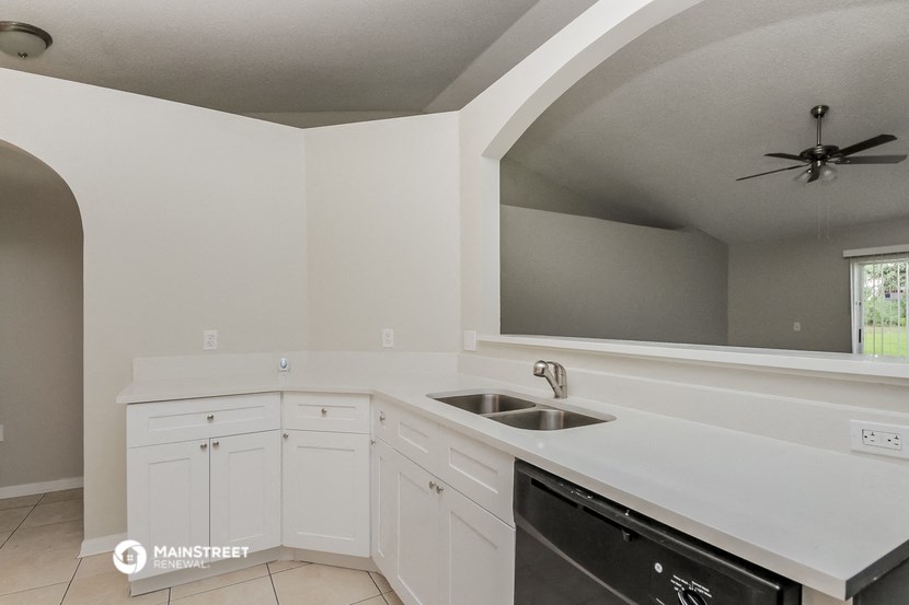 a kitchen with white cabinets and a sink and a dishwasher