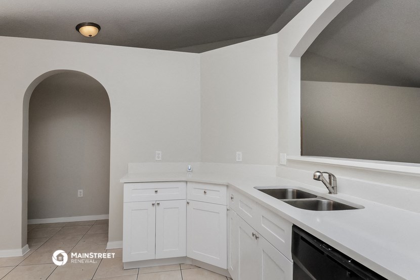 a kitchen with white cabinets and a sink