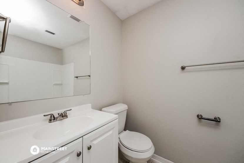 a bathroom with a sink toilet and a mirror
