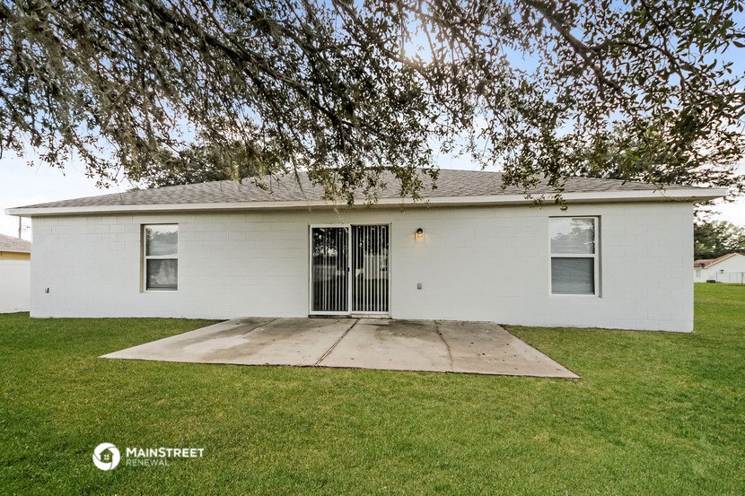 a small white house with a yard and a tree