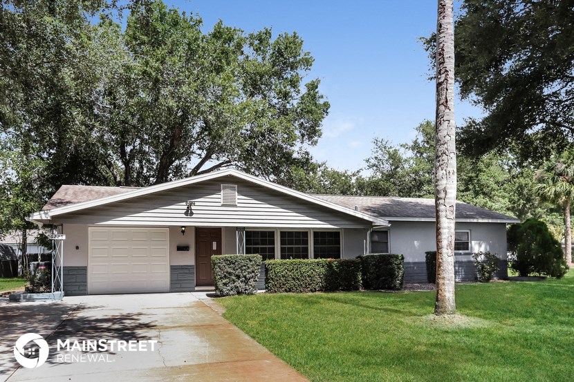 a white house with a tree in front of it