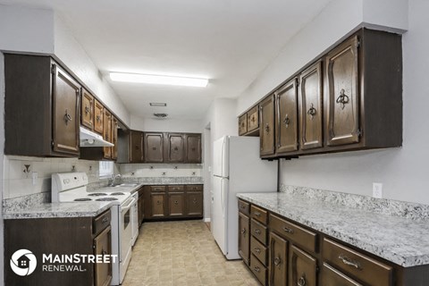 a kitchen with marble counter tops and wooden cabinets