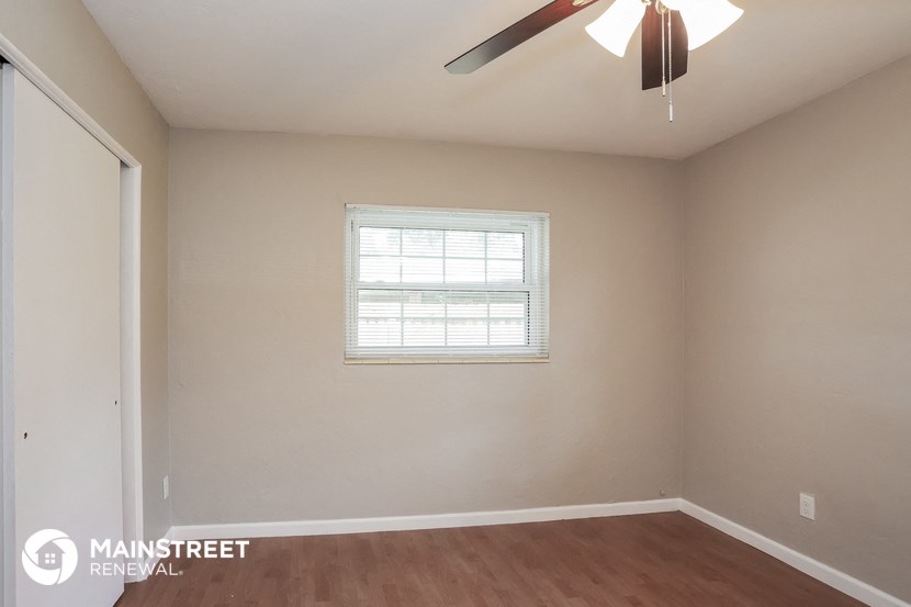 a bedroom with a ceiling fan and a window
