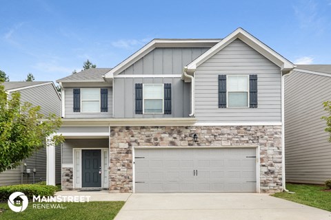 a gray house with a garage door in front of it