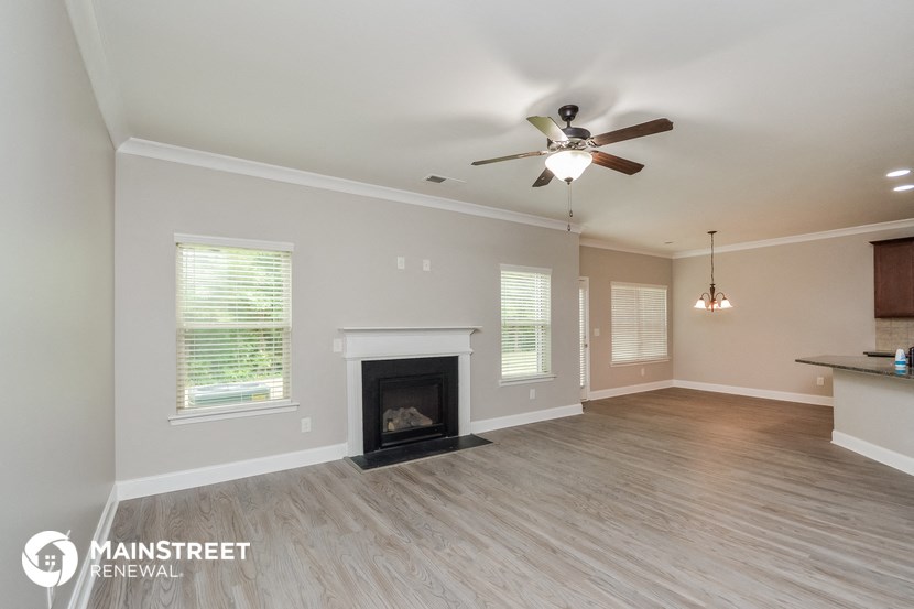 a living room with a fireplace and a ceiling fan