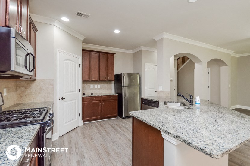 a kitchen with granite counter tops and wooden cabinets
