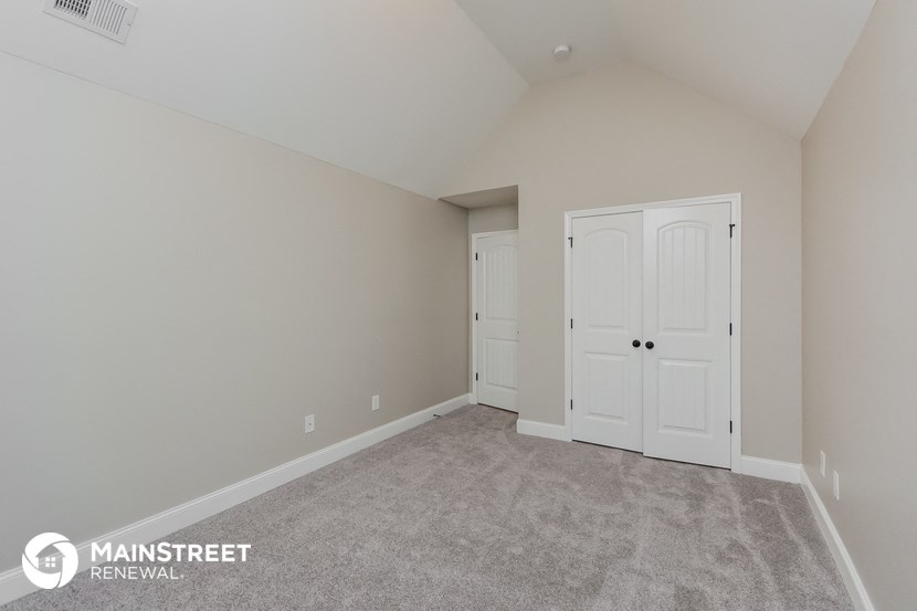 the master bedroom has a carpeted floor and white doors