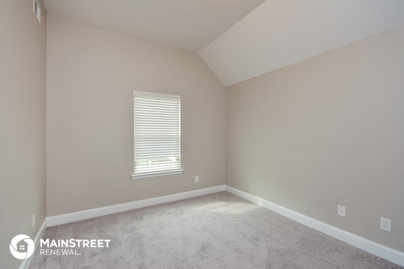 the upstairs bedroom with carpet and window