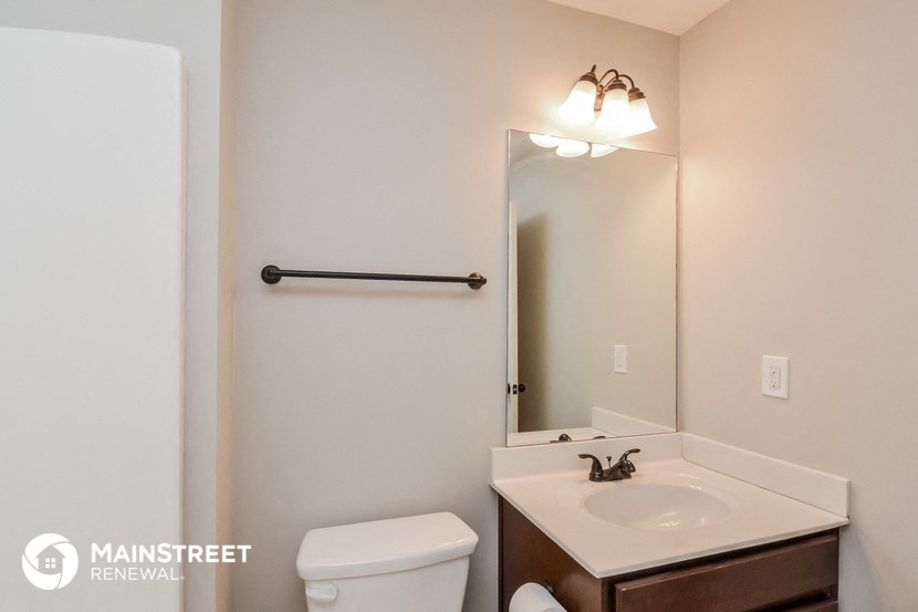 a bathroom with a toilet and a sink and a mirror