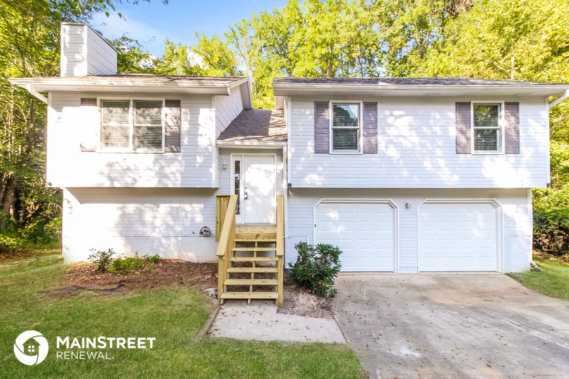 a white house with a ladder in front of a driveway