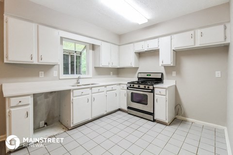 a kitchen with white cabinets and a stove and a sink