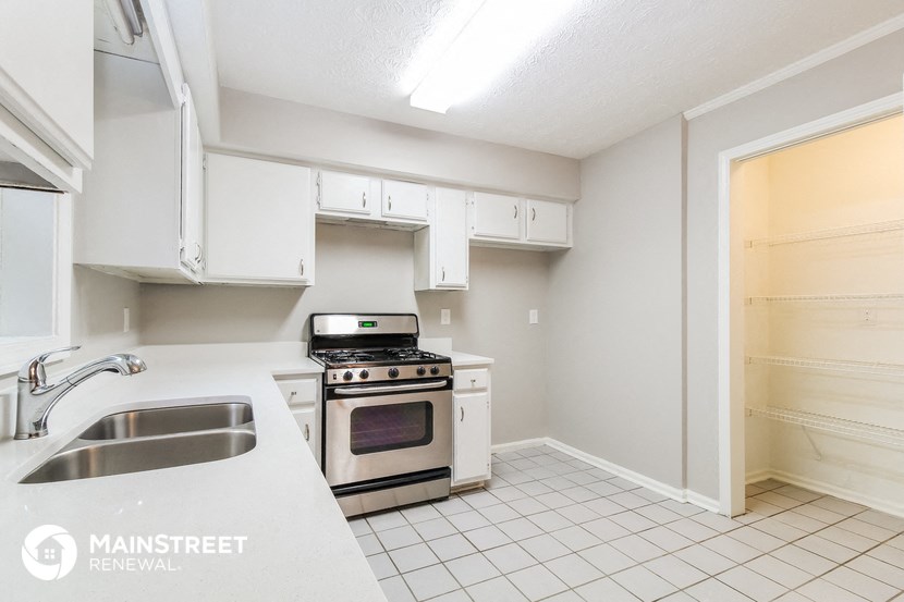 a kitchen with white cabinets and appliances and a sink