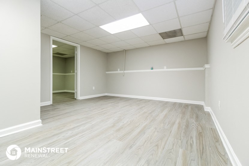the interior of an empty room with wood floors and white walls