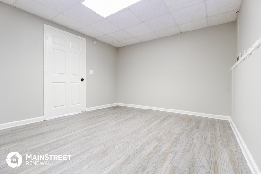 the living room of a new home with wood floors and a white door