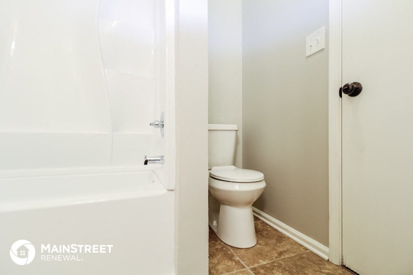 a bathroom with a toilet and a tub and a shower