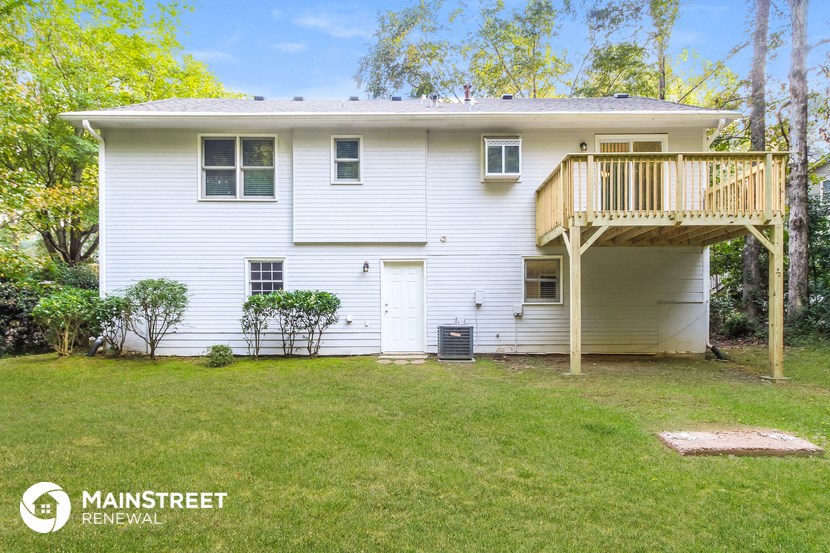 a white house with a backyard and a deck
