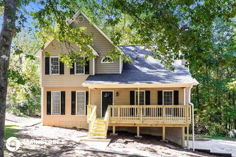 a yellow house with a porch and a blue roof