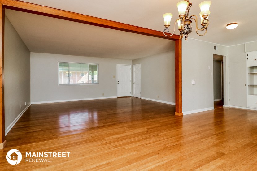 the living room and dining room of a house with wood floors