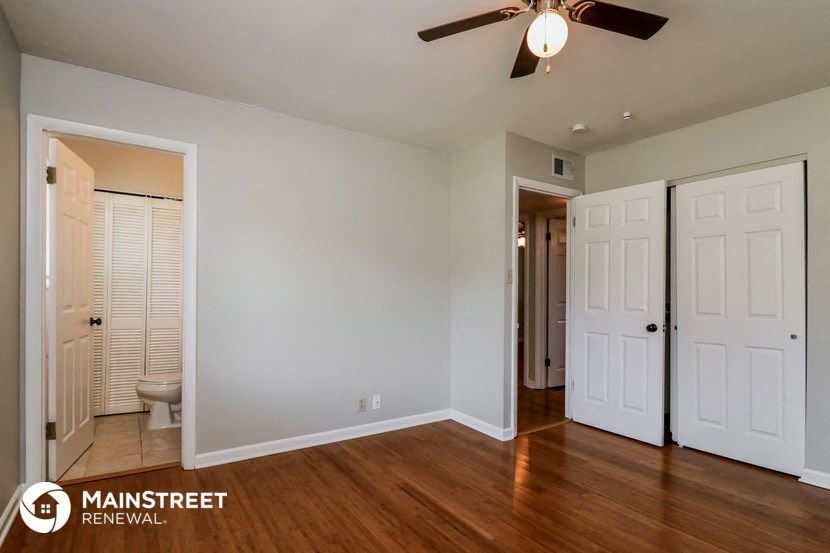 a bedroom with two closets and a ceiling fan