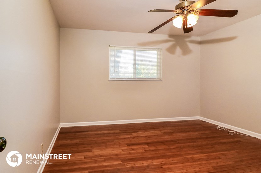 the bedroom with hardwood flooring and a ceiling fan