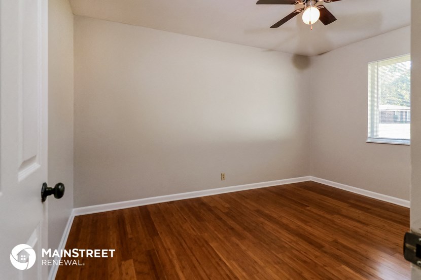 the bedroom with hardwood flooring and a ceiling fan