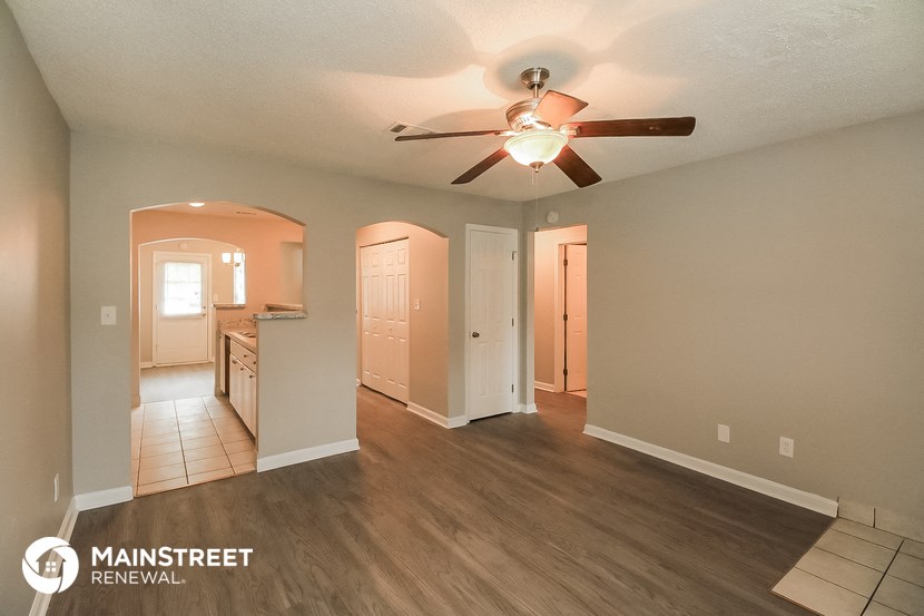 the living room and dining room with a ceiling fan
