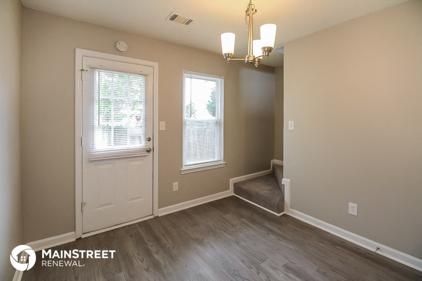 the living room of a house with a white door and a window