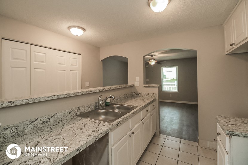 a kitchen with white cabinets and a sink and a counter top