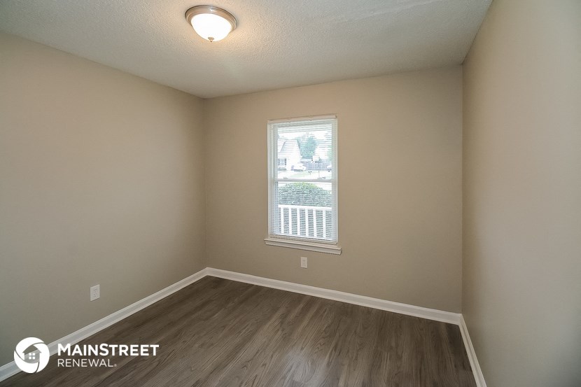 the interior of an empty room with wooden floors and a window