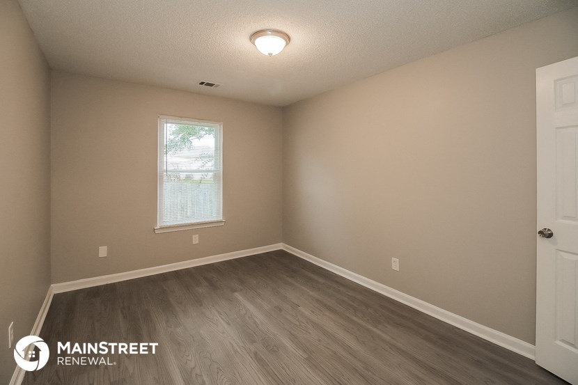 the interior of an empty room with wooden floors and a window