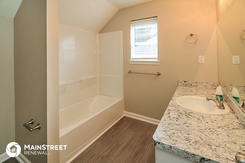 a bathroom with a sink and a shower and a tub