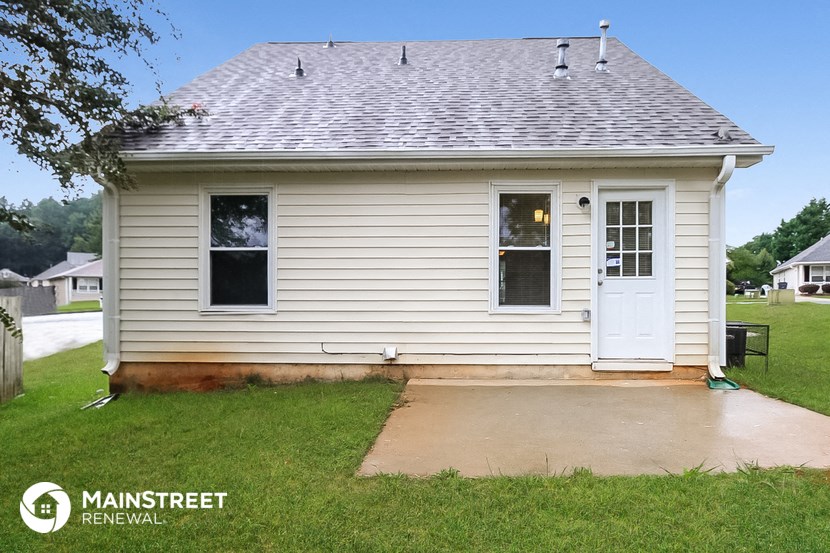 the front of a white house with a porch and a driveway
