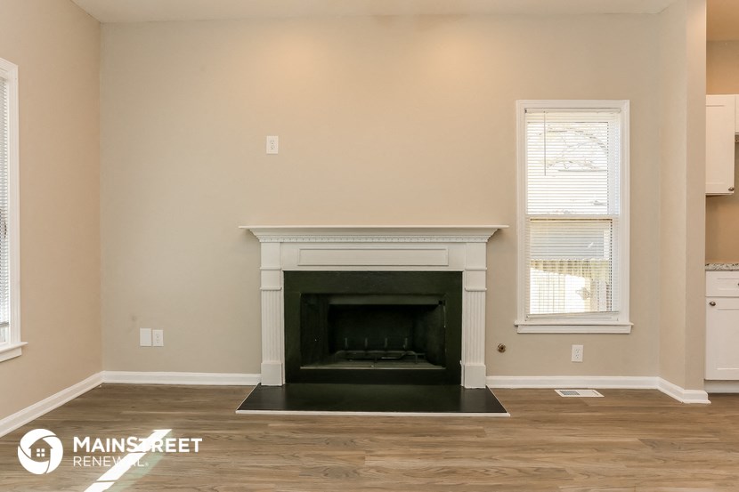 a living room with a fireplace and a wooden floor