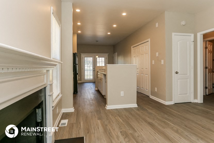 a living room with a fireplace and a kitchen