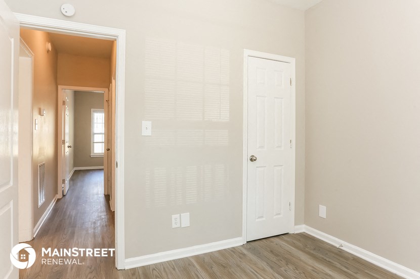 the living room of an apartment with a door to the hallway