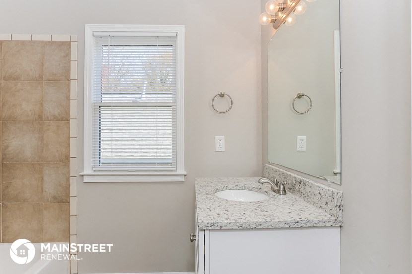 a bathroom with a sink and a mirror and a window